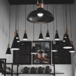 Moderne woonkamer met een stijlvolle zwarte hanglamp die een sfeervolle ambiance creëert.